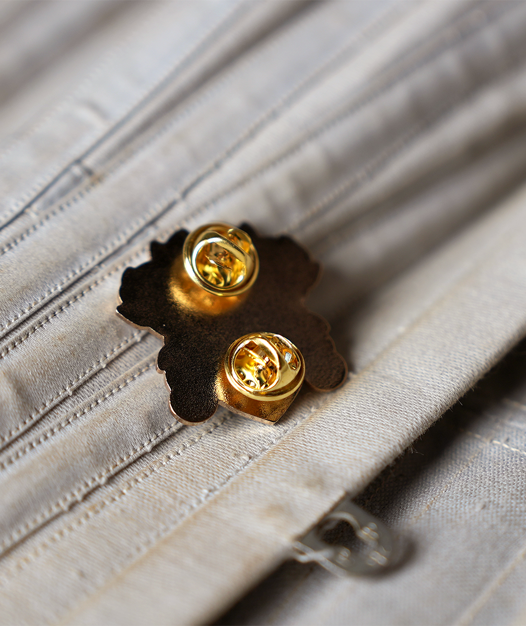 Shows the gold back of the pin with two butterfly clasps.