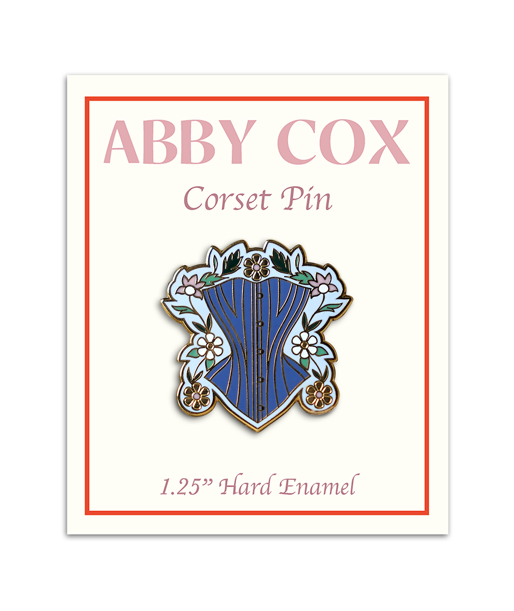 Pin is about 1.25" tall and depicts a powder blue corset surrounded by gold, white, and pink daises with green leaves and a light blue background. Pin is on a paper card backer with Abby Cox written on the top with text "Corset Pin" beneath and then "1.25" Hard Enamel" written below the pin.