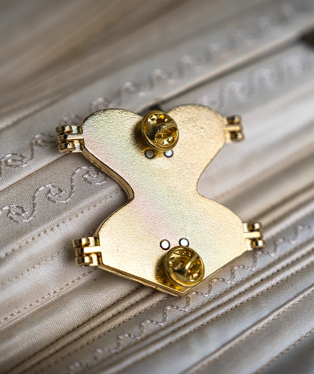 Back of gold hard enamel pin shows the two butterfly clasps and the magnets on the back to keep the pin closed.