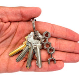 Hand holding key ring with keys and molecule keychain.