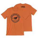 An orange t-shirt that has The Newest Olympian logo on the back neck area and a circular design on the front of a running horse with test that reads "Camp Regular Person; Regular Long Island; Regular New York".