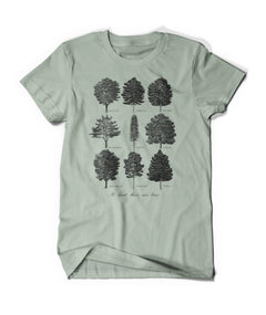 Light green short sleeve shirt with printed design of scientifically illustrated trees in black ink. Text on bottom written in script reads "At least there are tress"