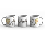 White mug with a full wrap design. Design is of an illustrated version of Hank and John Green with their microphones. In between them is the word, "Vlogbrothers" written out in cursive but the line is continuous and links Hank's microphone to John's.