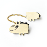 Two pieces of a golden pin that are attached by a gold chain. The front of the pin is the head of Jacob Horse and the other is the back half. From Drawfee.