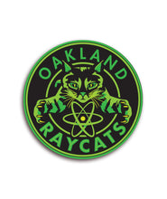 Green and black circular sticker centering a cat with the phrase "Oakland Raycats" around it - by 99% Invisible