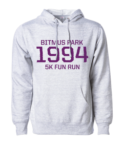 Heather white hoodie with large red 1994 in the front center and "Bitmus Park 5K Fun Run" sandwiched around it in smaller font. The hoodie has a front pocket on the bottom. By Brian David Gilbert