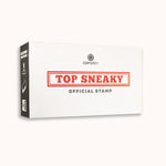 A white box with black sides. CGP Grey logo at the top. Below, "TOP SNEAKY” written in a red serif font surrounded by a red box. “Official Stamp” is written underneath in gray sans serif font. The side has an image of the contents of the box - from CGP Grey.