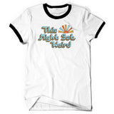 A white short sleeve shirt. The arm and neck holes have black collars. The text “This Might Get Weird” is displayed large across the chest in light blue with multicolored outlines. Next to “This” is a stylized sun with the same colorful rays.