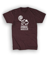 Dark maroon shirt with Animal Wonders in center of shirt in white. Logo is of cartoon silhouette drawing of monkey with spiral tail is above “Animal Wonders INC” with each word all caps, sans serif font, and varying sizes. INC is on its side at end of the word Wonders, both are below “Animal" - from Animal Wonders