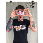 A signed photo of Charles Trippy holding an iphone showing a photo of eyes over his eyes