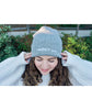 A woman modeling a gray beanie with “confident & kind” in white cursive font across the cuff - from Sierra Schultzzie