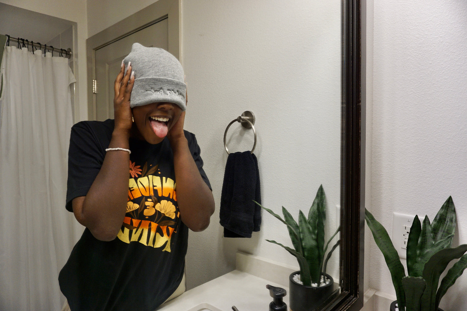 A woman modeling a gray beanie with “confident & kind” in white cursive font across the cuff - from Sierra Schultzzie