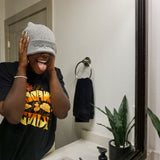 A woman modeling a gray beanie with “confident & kind” in white cursive font across the cuff - from Sierra Schultzzie