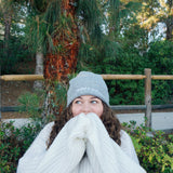 A woman modeling a gray beanie with “confident & kind” in white cursive font across the cuff - from Sierra Schultzzie