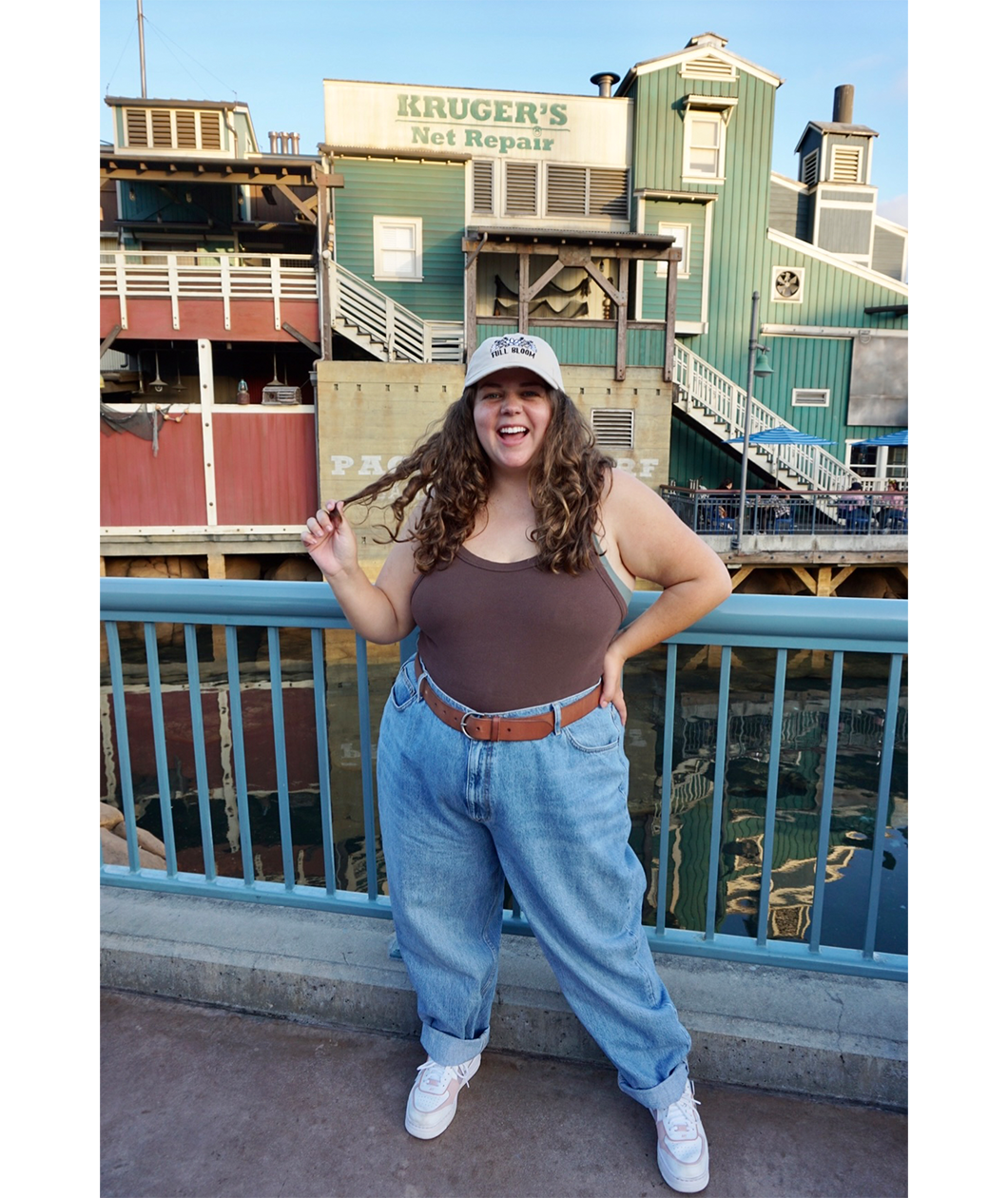 Sierra Schultzzie wearing a beige ball cap with the embroidered words "Full Bloom" with flowers.