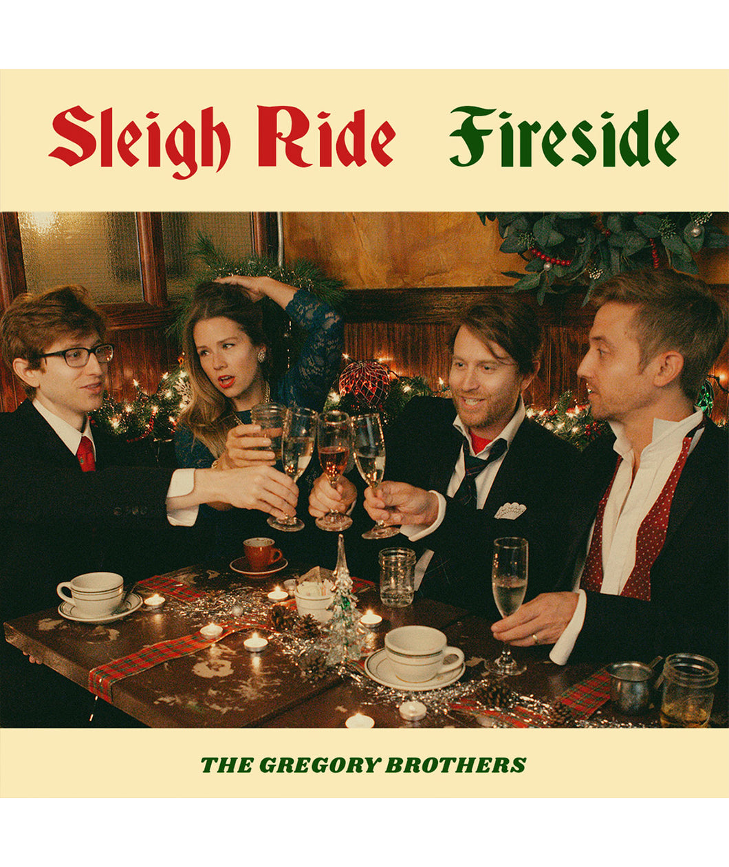 An album cover featuring four people posed in suits and a dress, sitting around a festive table, clinking glasses. On the cover it reads "Sleigh Ride Fireside; The Gregory Brothers".