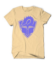A yellowish cream colored t-shirt with a centered large purple illustration of a dragon's head peering at the pages of an open book, with a crest shape in the background. 