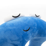 A closeup of a blue neck pillow in the shape of a pi character. The pillow is blue, and the pi character has a sleeping face. From 3Blue1Brown.