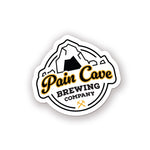 A sticker of a fake brewing company logo. The logo is of a cave with the text, "Pain Cave Brewing Company" beneath it. From Courtney Dauwalter.