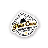 A sticker of a fake brewing company logo. The logo is of a cave with the text, "Pain Cave Brewing Company" beneath it. From Courtney Dauwalter.