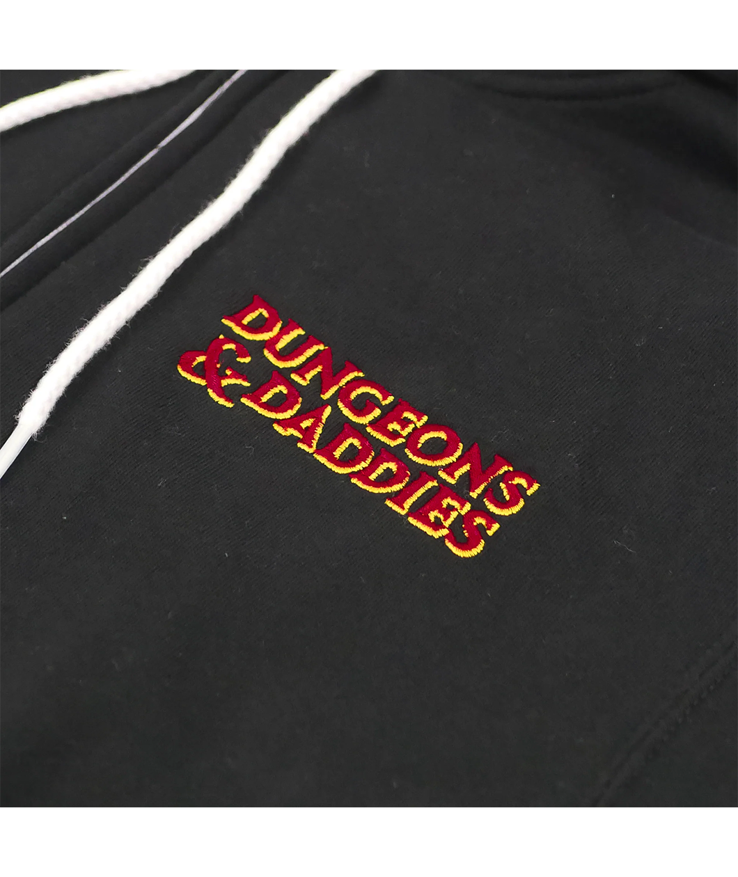 Close up of embroidered Dungeons & Daddies logo in red and yellow.