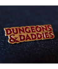 Gold plated enamel pin of Dungeons & Daddies logo in red enamel.