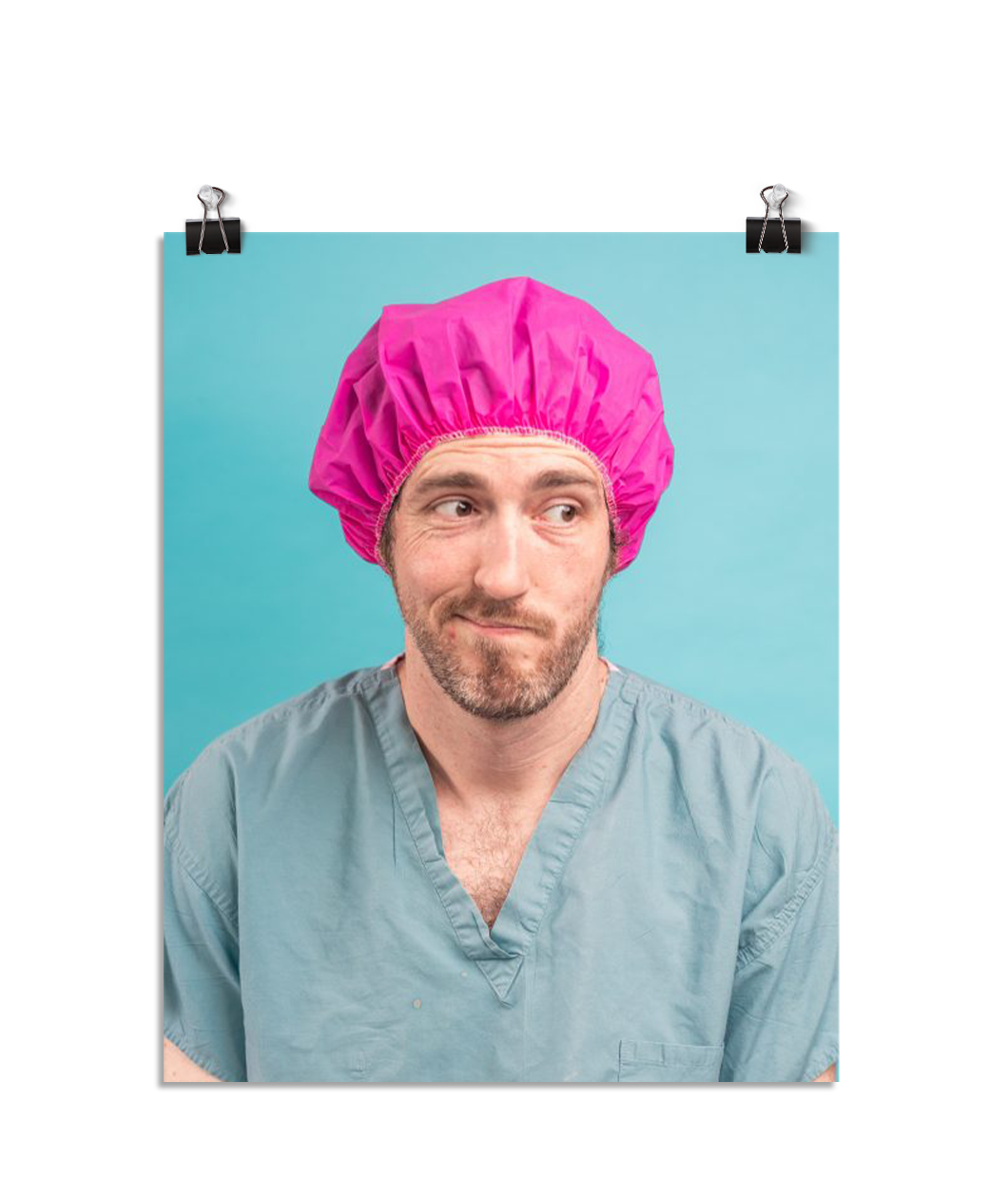 Photo of a man in green scrubs and a hot pink hair net looking to the side like "welp". On a seafoam colored background.