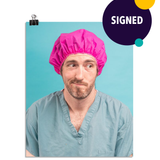 Photo of a man in green scrubs and a hot pink hair net looking to the side like "welp". On a seafoam colored background. This print is signed by the doctor!