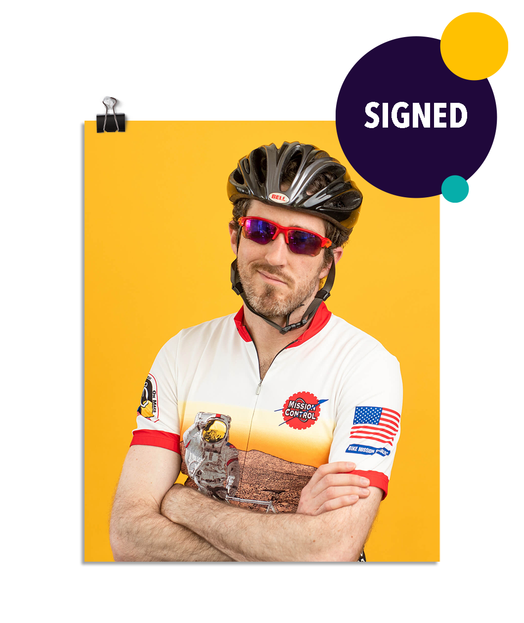 Photo of a man crossing his arms in a zip up bike shirt, bike helmet, and sun glasses smirking at the camera. On a yellow background. This print is signed by the doctor!