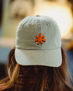 Light denim colored hat with orange asterisk embroidered on the front center.
