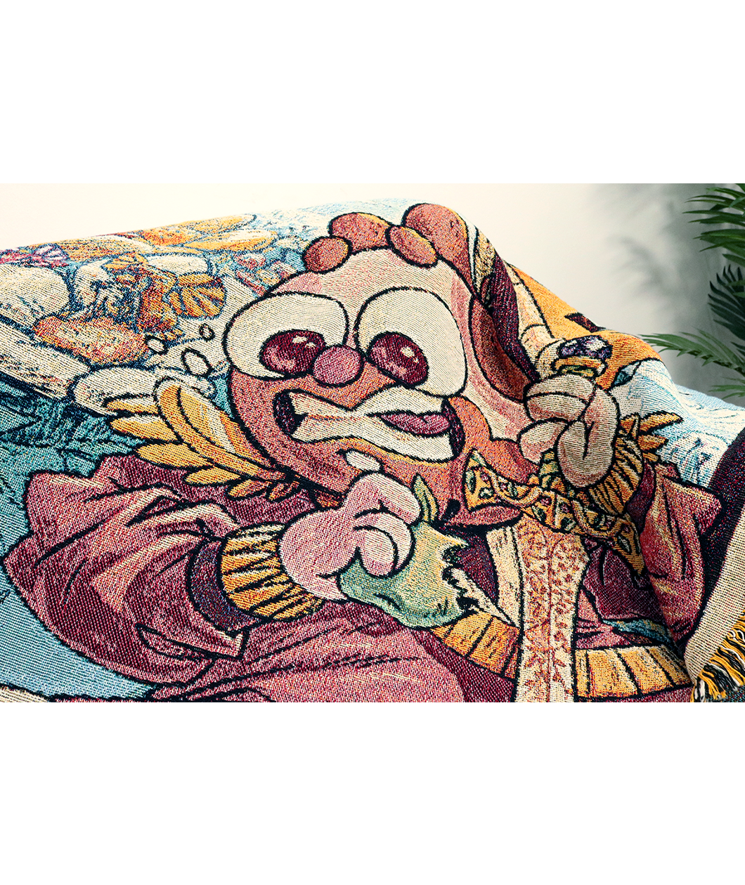 Detailed image of the Cox illustration of the blanket showing the cartoon character with red hair and a bear biting an apple and holding a golden sword pointed downward.