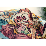 Detailed image of the Cox illustration of the blanket showing the cartoon character with red hair and a bear biting an apple and holding a golden sword pointed downward.