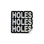 3" vinyl die cut sticker with bold block text. A Black sticker with glittery text says, "HOLES HOLES HOLES".