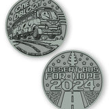A digital mockup of a dark silver coin. The front shows an image of a bus with the text "One DBloon; Agimus Liberos Adjutum" The back shows an image of a road and tree-shaped air freshener with the text "Desert Bus for Hope 2024"