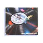 A photo of the front of the Desert Bus for Hope 2023 photo book. It features a vinyl record with confetti fallen over it.