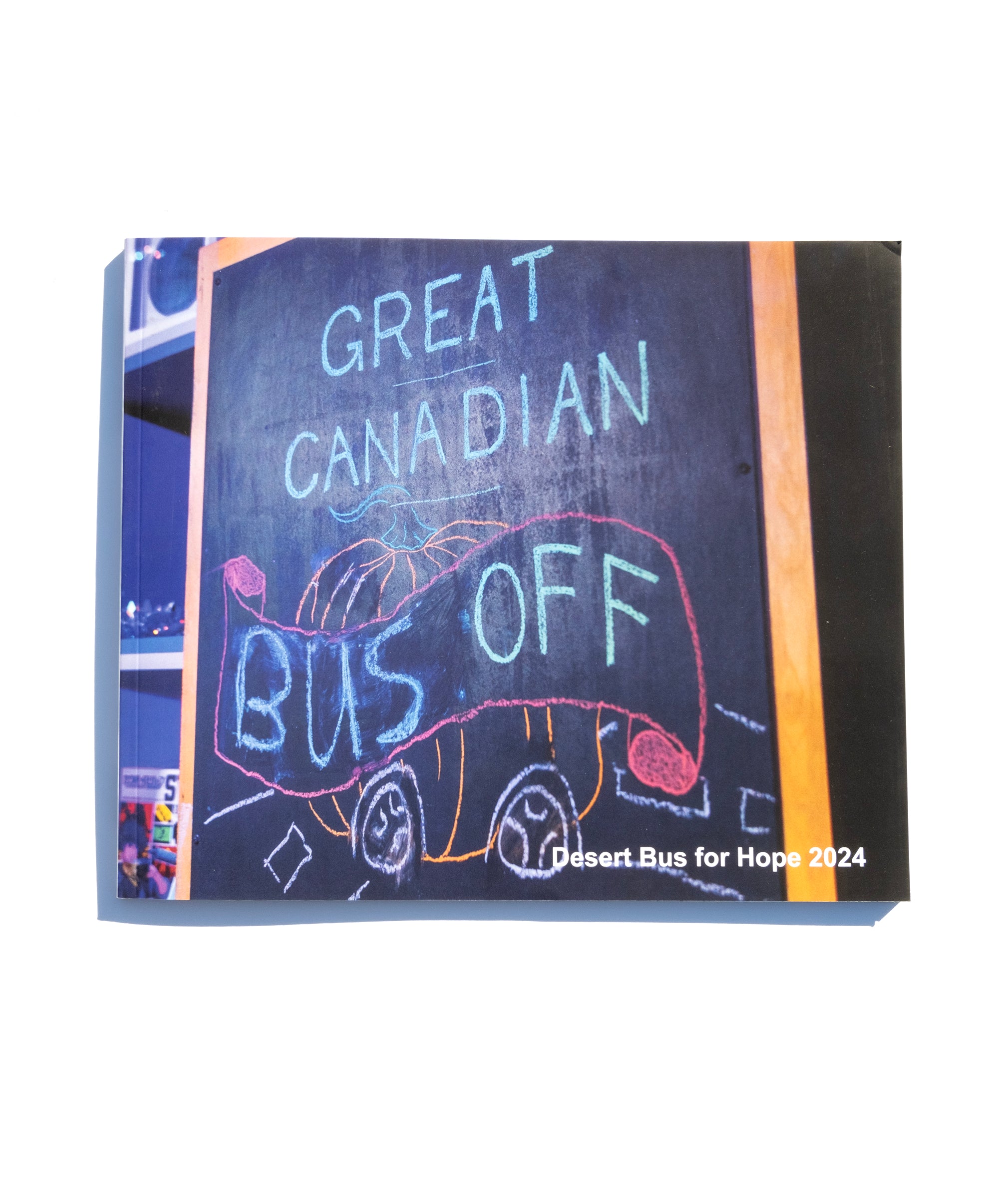 A photo of the front of the Desert Bus for Hope 2024 photo book. It features a chalkboard illustration that reads "Great Canadian Bus Off"