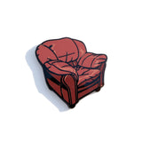 A photo of a pin designed to resemble the big leather chair from the Desert Bus streaming space.