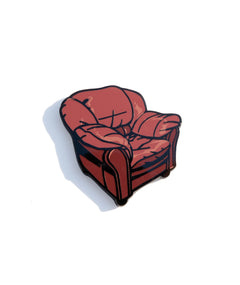 A photo of a pin designed to resemble the big leather chair from the Desert Bus streaming space.
