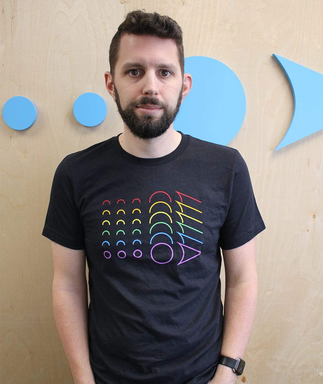 Man wearing a black t-shirt with a rainbow loadingreadyrun logo printed on the chest