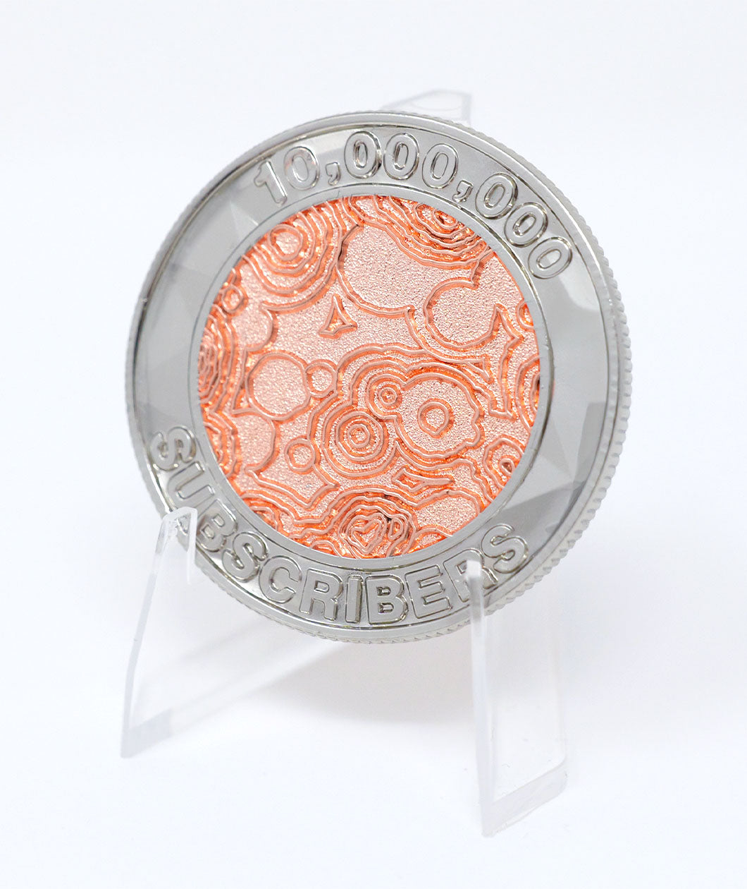 A photo showing a coin on a plastic stand. It has the NileRed logo and the text "10,000,000 Subscribers" with a diamond fractal pattern.