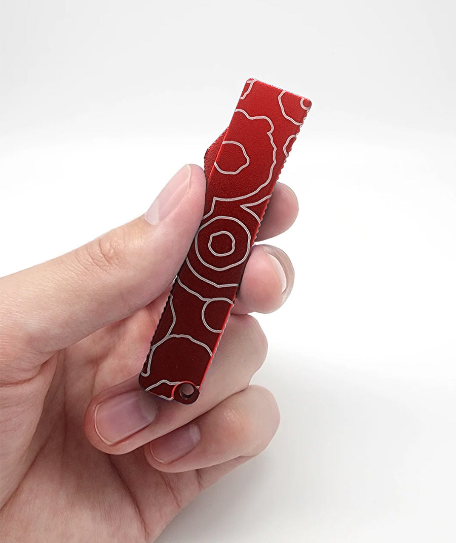 A hand holding a closed bottle opener