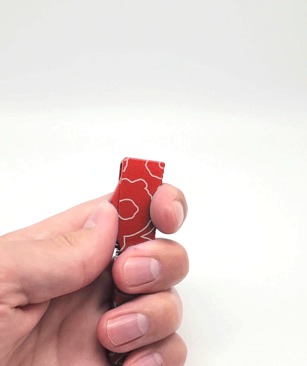 An animated photo gif of a hand opening and closing a red bottle opener