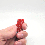 An animated photo gif of a hand opening and closing a red bottle opener