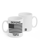 Two white mugs sitting next to each other showing two sides of the same mug. The front side has text that reads "Defend; Tofu" with a black and white American flag in the center. On the back of the mug is a small black square with the words "Semi Rad".