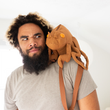 Man looking puzzled at a cicada shell shaped backpack resting on his shoulder like a parrot. Clearly a personality pic.