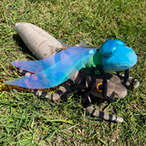 Bright blue dragonfly plush emerging from its larve taupe colored plush shell.