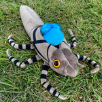 Bright blue dragonfly plush emerging from its larve taupe colored plush shell.