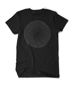 Black shirt with a spiral circle that fades from white to black inward. Text says, "We're Here Because" and repeats over and over.