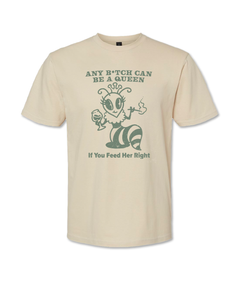 Natural colored t shirt with screen printed sage green text & artwork that says, "Any Bitch can be a queen" with an illustration of a queen bee smoking a long cigarette and drinking a glass of wine. Underneath it says, "If you feed her right"