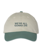 Khaki colored dad hat with sage green brim and embroidery that is front and centered and says in bold uppercase font, "WE'RE ALL GONNA DIE"